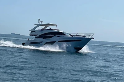 2020 Princess F55 yacht cruising on open sea under clear blue sky.