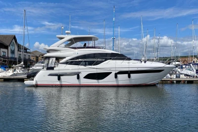 Luxury 2020 Princess F55 yacht docked in marina under blue sky.