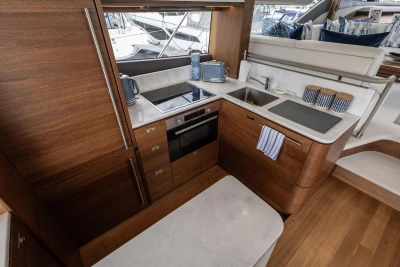 Luxurious kitchen interior of 2020 Princess F55 yacht with modern appliances and wooden cabinetry.