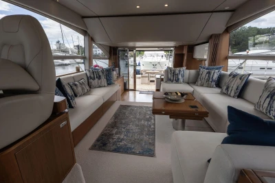 Luxurious interior of 2020 Princess F55 yacht with elegant seating and scenic marina view.