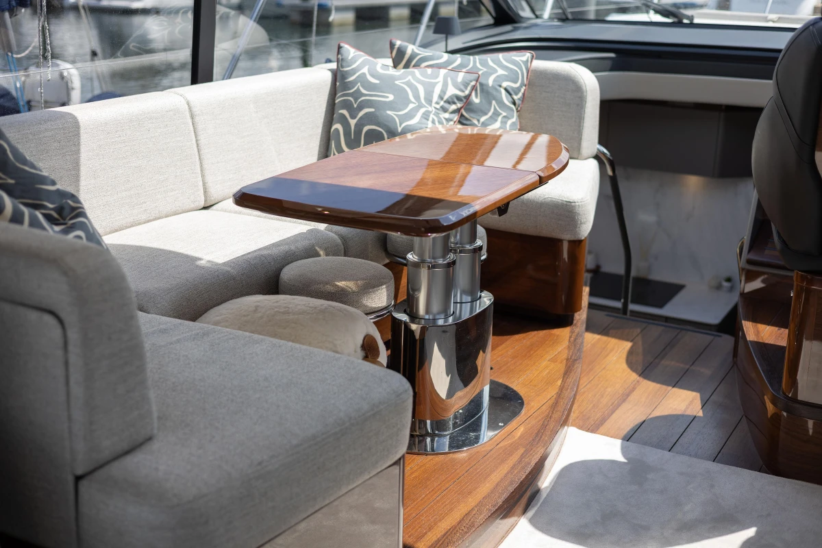 Luxurious interior of 2023 Princess V50 yacht with elegant seating and polished wood table.