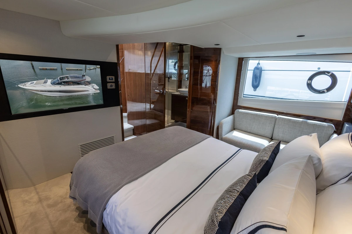 Luxurious 2023 Princess V50 yacht bedroom with modern decor and large window view.