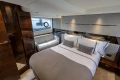 Luxurious bedroom interior of 2023 Princess V50 yacht with elegant bedding and seating area.