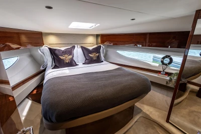 Luxurious 2023 Princess V50 yacht bedroom with elegant bedding and modern design.