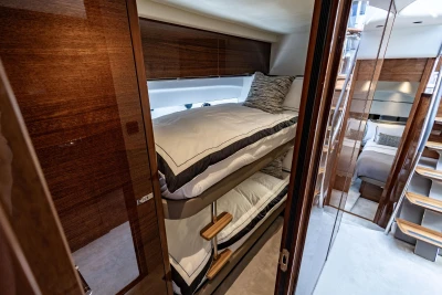 Luxurious 2023 Princess V50 yacht interior with elegant wooden finishes and cozy bunk beds.