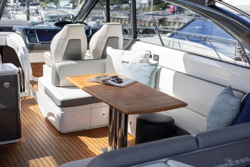 Luxurious 2015 Princess V48 Open yacht interior with elegant seating and wooden table.