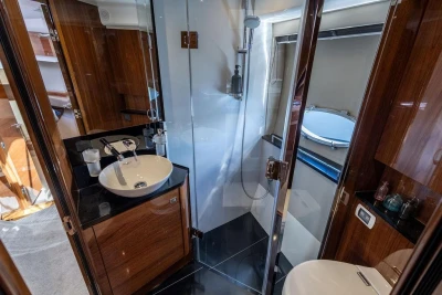 Luxurious bathroom interior of 2015 Princess V48 Open yacht, featuring modern fixtures and elegant wood finishes.
