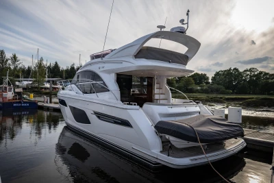 Luxury 2019 Princess F50 yacht docked at marina under cloudy sky.