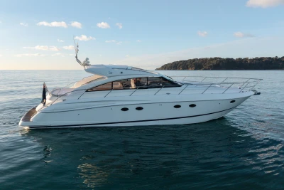 2006 Princess V53 yacht cruising on calm waters under a clear sky.