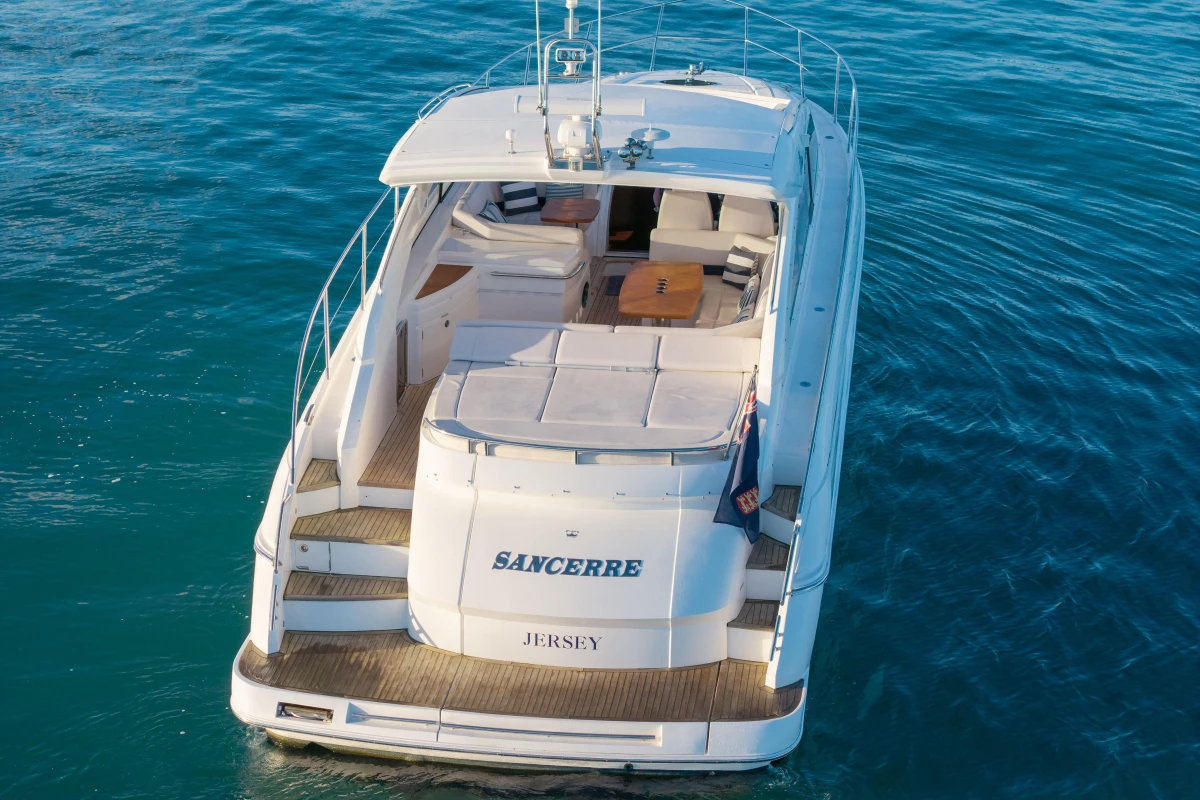2006 Princess V53 yacht on calm blue water, rear view with deck seating.