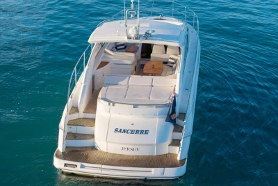 2006 Princess V53 yacht on calm blue water, rear view with deck seating.