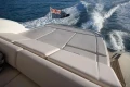 Luxurious 2006 Princess V53 yacht cruising with flag, rear deck view.