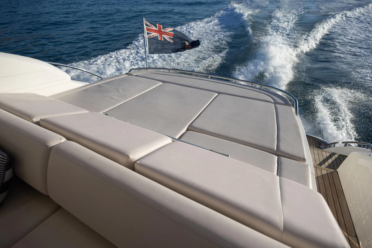 Luxurious 2006 Princess V53 yacht cruising with flag, rear deck view.
