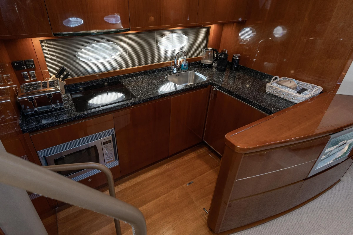 Luxurious 2006 Princess V53 yacht kitchen with modern appliances and sleek wood finish.