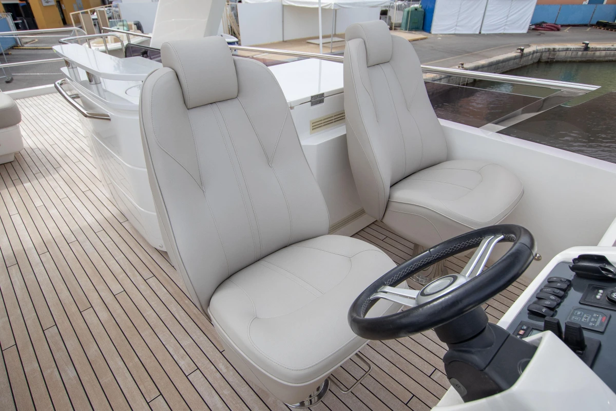 Luxury yacht helm with dual seats, Princess 68 model, 2015, featuring sleek design and controls.