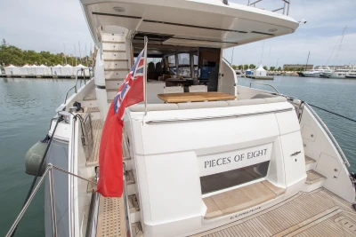 Luxury 2015 Princess 68 yacht docked, featuring spacious deck and elegant design.