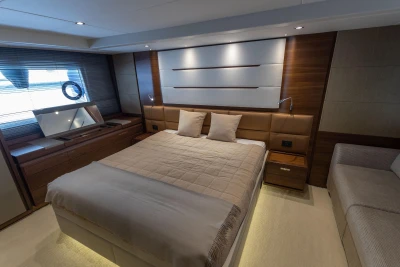 Luxurious bedroom interior on a 2015 Princess 68 yacht, featuring elegant wood finishes.