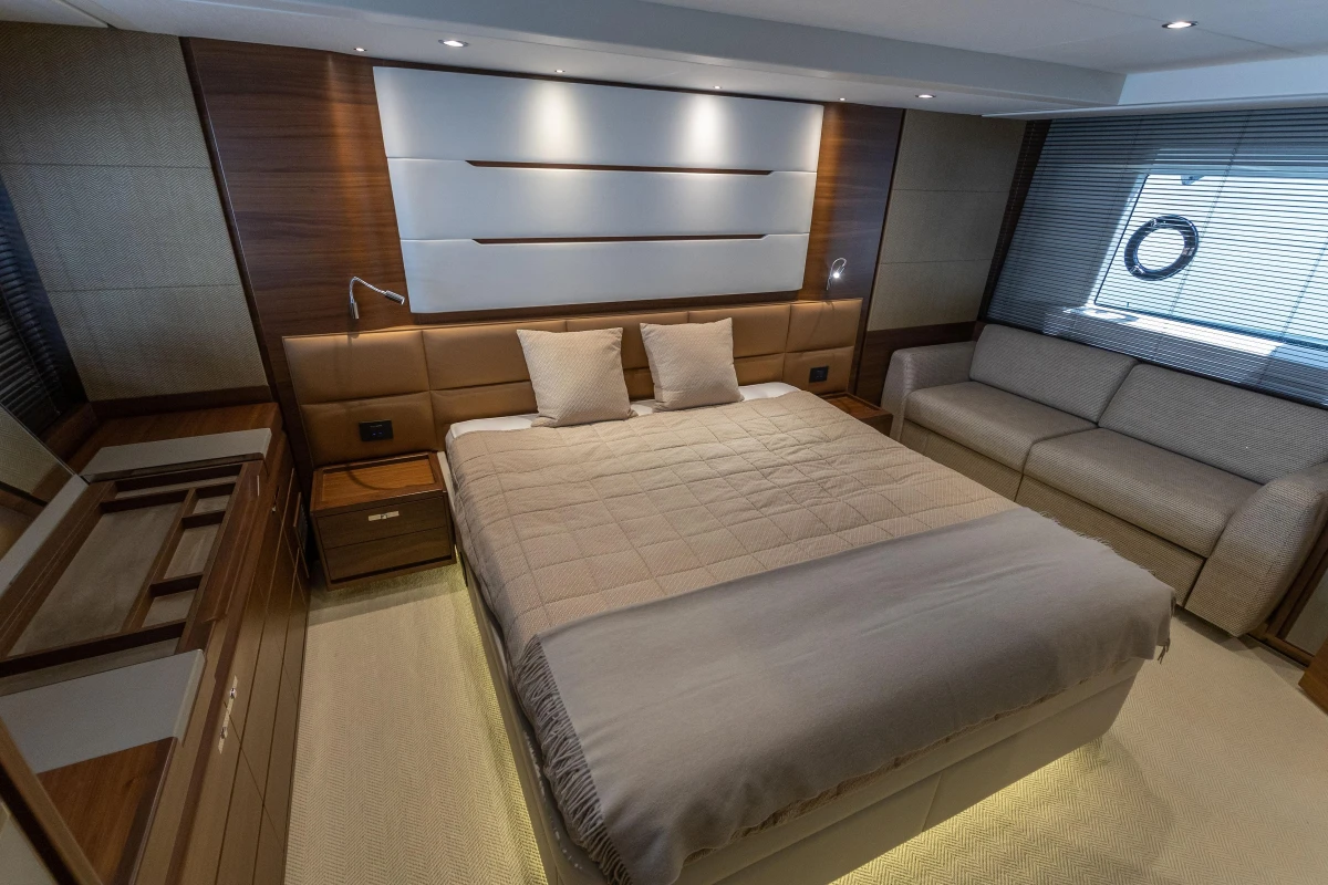Luxurious bedroom interior of 2015 Princess 68 yacht with modern design and cozy furnishings.