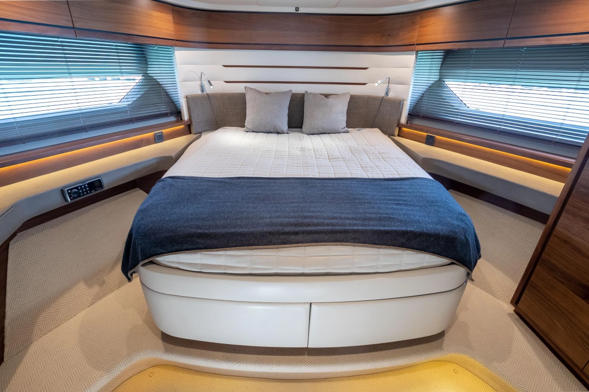 Luxurious bedroom interior of 2015 Princess 68 yacht with modern design and cozy bedding.