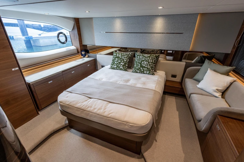 Luxurious cabin interior of 2025 Princess V55 yacht with elegant bedding and seating.