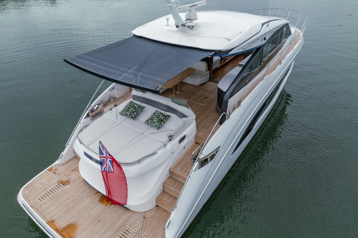 Luxurious 2025 Princess V55 yacht with sunshade and elegant deck design on calm water.