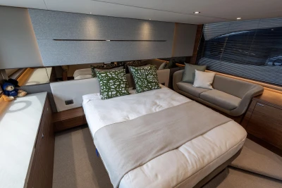 Luxurious bedroom interior of 2025 Princess V55 yacht with modern decor and cozy seating.