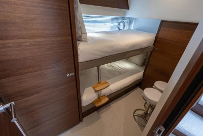 2025 Princess V55 yacht cabin with wooden interior and bunk beds.