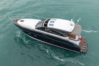 2014 Princess V48 yacht cruising on turquoise waters, aerial view.