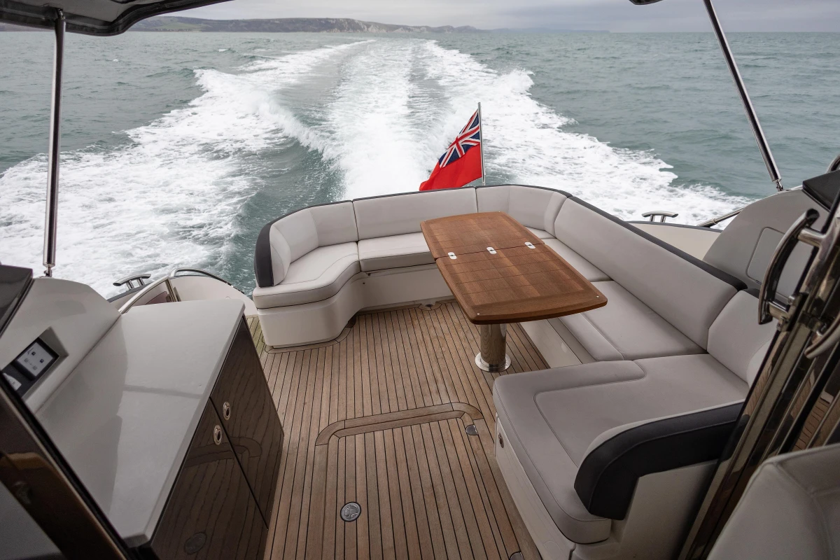 Luxurious 2014 Princess V48 yacht with elegant seating and wooden deck cruising at sea.