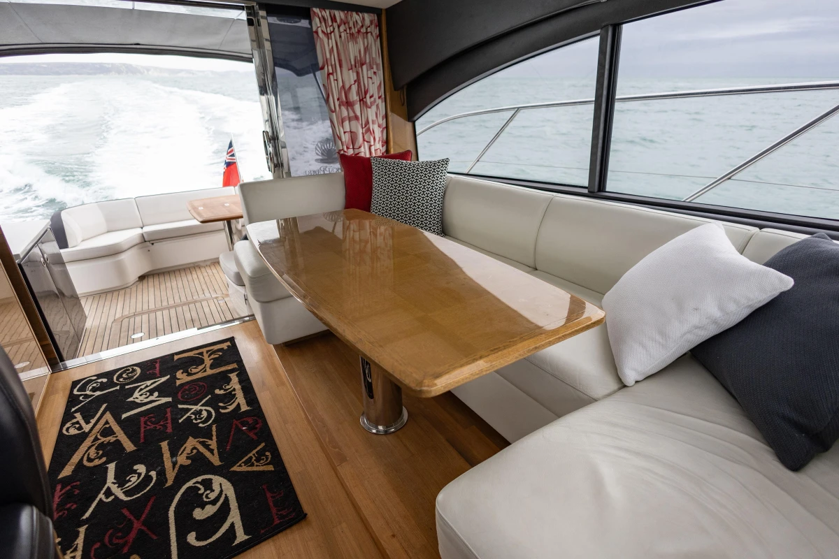 Luxurious interior of 2014 Princess V48 yacht with elegant seating and wooden table.