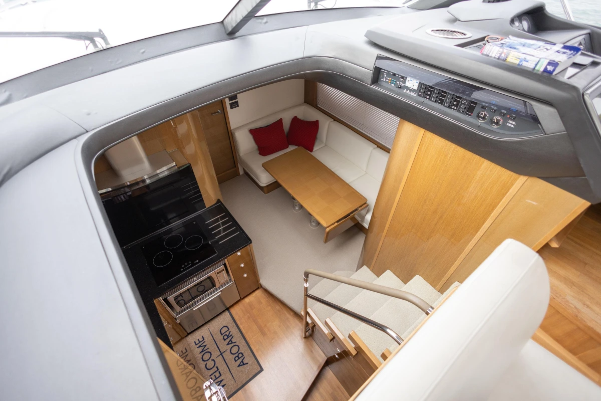 Luxurious interior of 2014 Princess V48 yacht with modern kitchen and cozy seating area.