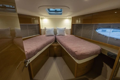 Luxurious 2014 Princess V48 yacht cabin with twin beds and elegant wood finish.