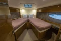 Luxurious 2014 Princess V48 yacht cabin with twin beds and elegant wood finish.