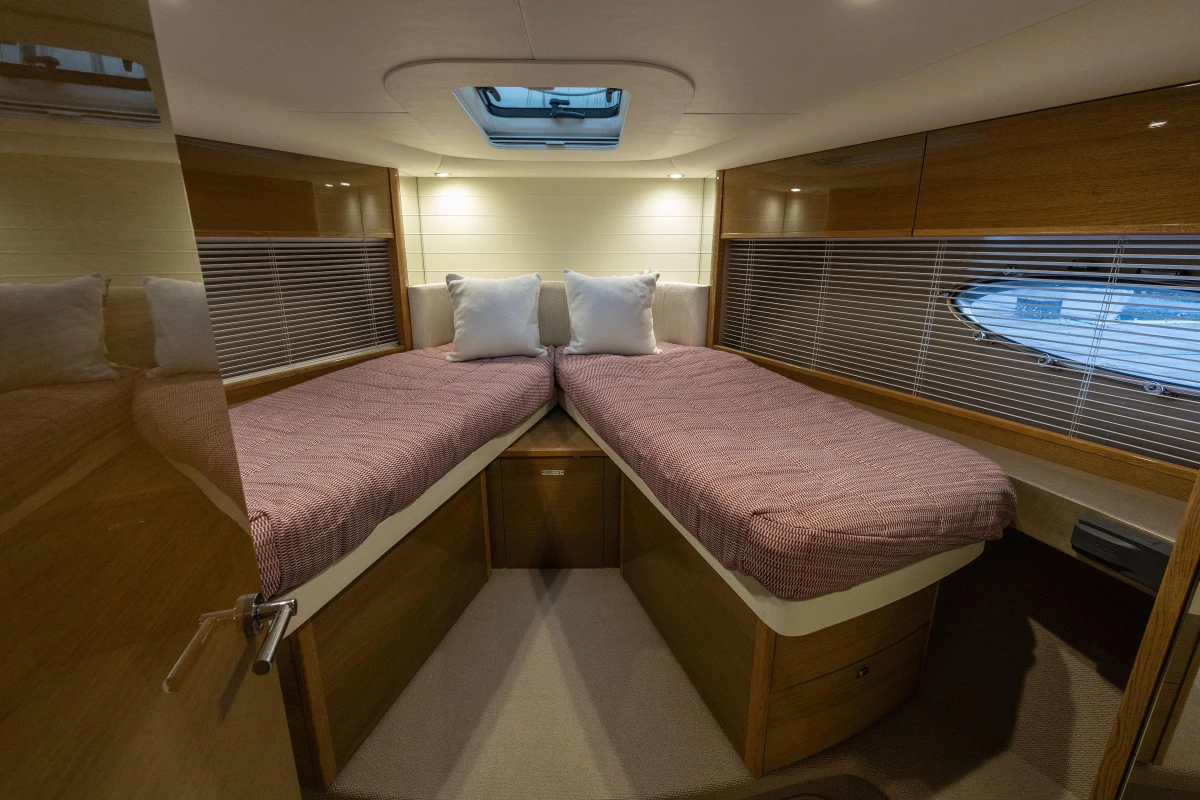 Luxurious 2014 Princess V48 yacht cabin with twin beds and elegant wood finish.