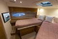Luxurious 2014 Princess V48 yacht cabin with twin beds and elegant decor.