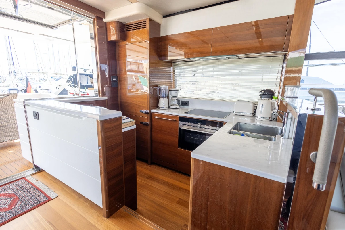Luxurious kitchen interior on a 2017 Princess 68 yacht with modern appliances and wood finishes.