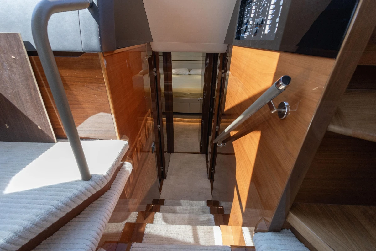 Interior staircase of 2017 Princess 68 yacht, featuring wooden finishes and modern design.