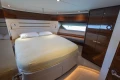 Luxurious bedroom interior on 2017 Princess 68 yacht with elegant wood finishes.