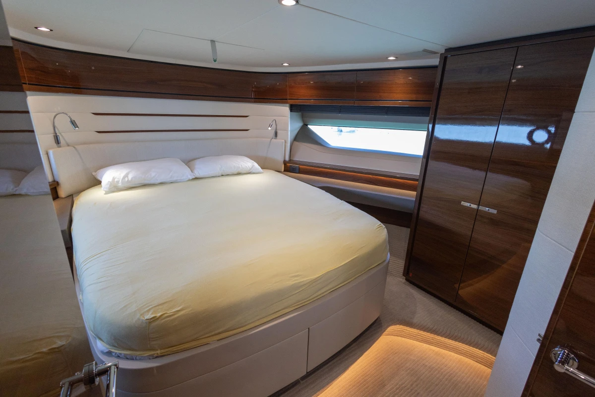 Luxurious bedroom interior on 2017 Princess 68 yacht with elegant wood finishes.