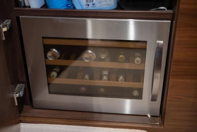 Built-in wine cooler on a 2017 Princess 52 yacht, featuring wooden shelves and stainless steel door.