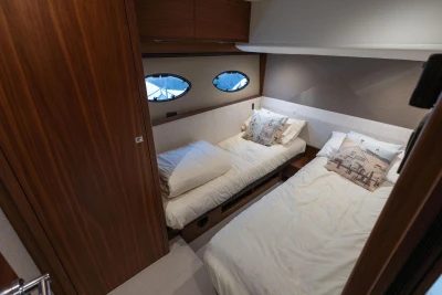 Luxurious cabin interior of 2017 Princess 52 yacht with twin beds and nautical decor.