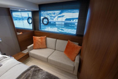 Luxurious interior of 2017 Princess 52 yacht with cozy sofa and orange cushions.