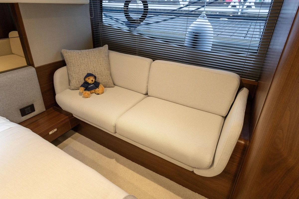 Interior of 2025 Princess F50 yacht with sofa and teddy bear.