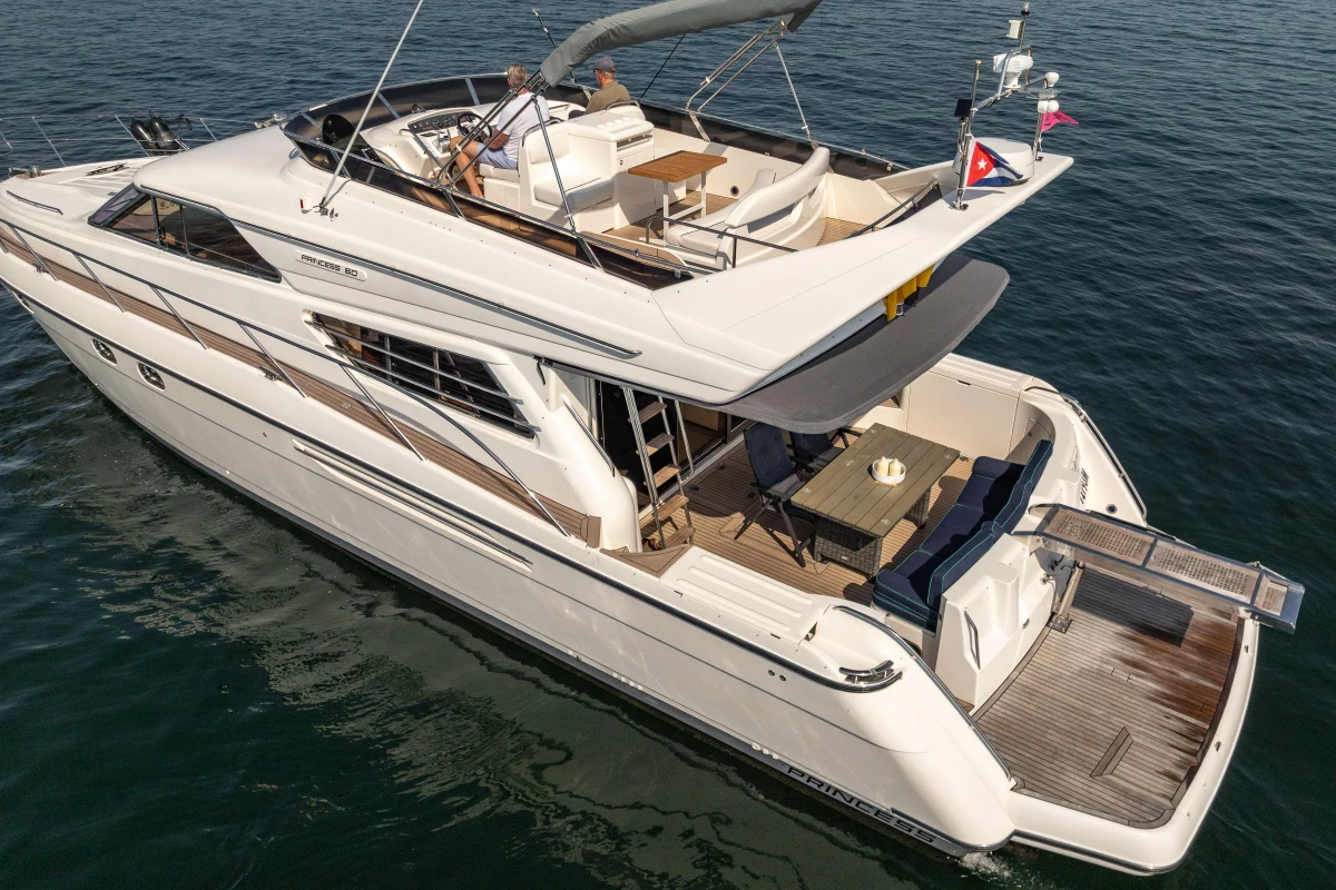 Luxury 1995 Princess 60 yacht cruising on open water, featuring spacious deck and elegant design.