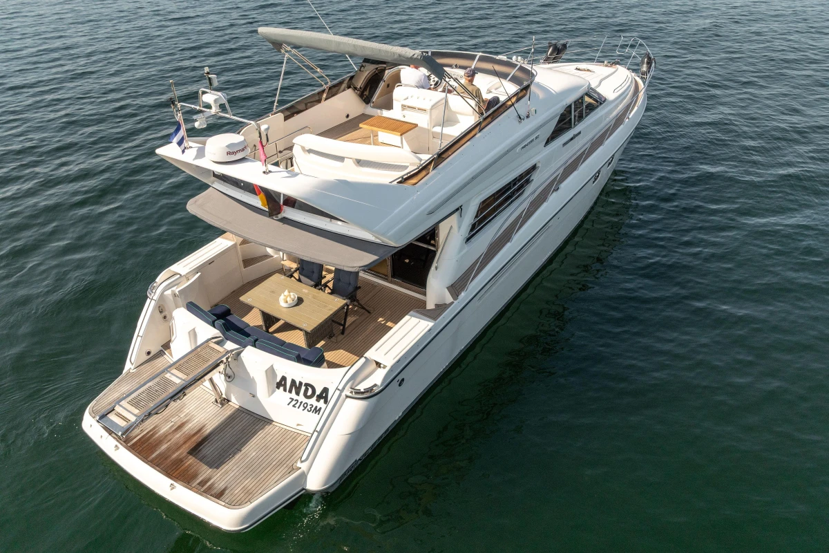 Luxurious 1995 Princess 60 yacht cruising on calm waters, featuring spacious deck and elegant design.