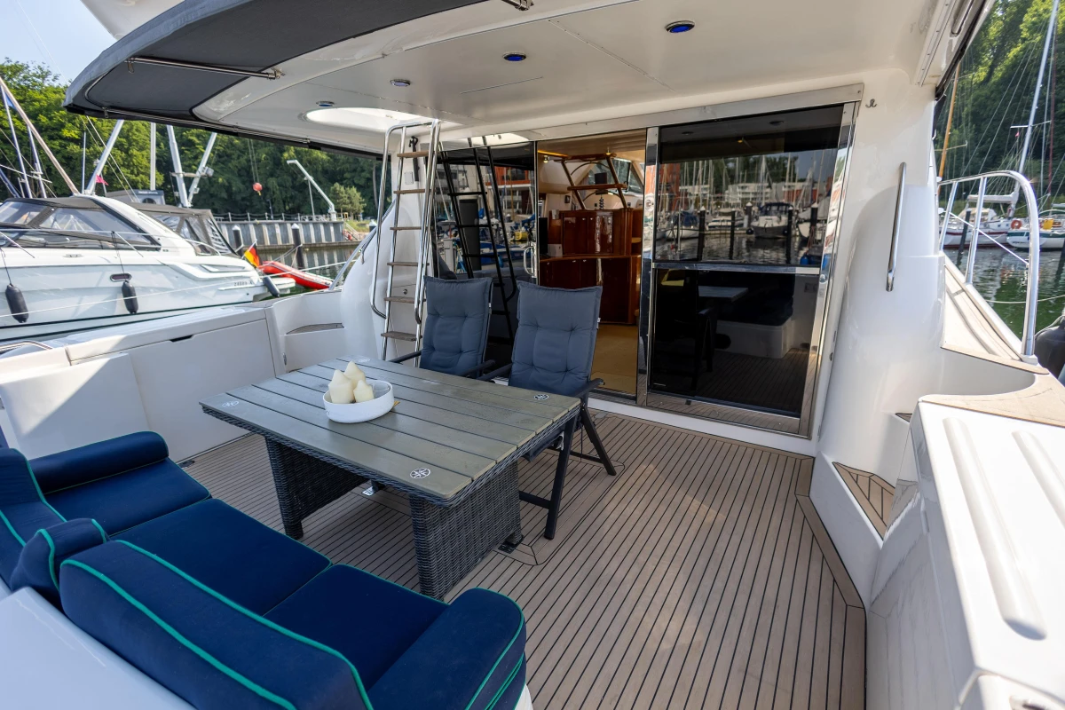 Luxurious 1995 Princess 60 yacht deck with seating, table, and marina view.
