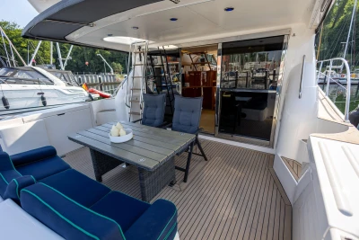 Luxurious 1995 Princess 60 yacht deck with seating, table, and marina view.