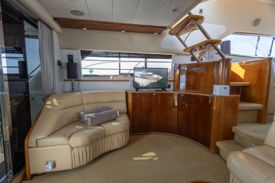 Luxurious interior of a 1995 Princess 60 yacht with leather seating and wooden cabinetry.