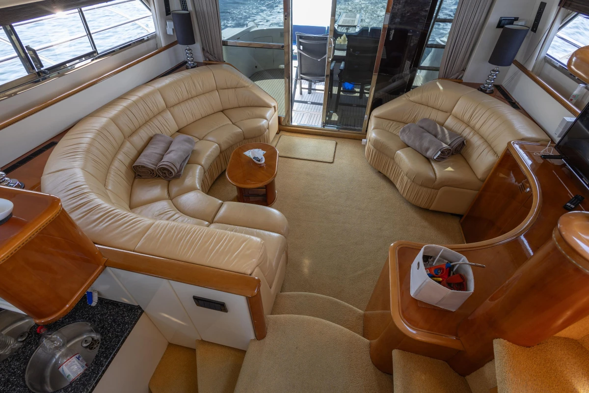 Luxurious interior of a 1995 Princess 60 yacht with beige leather seating and ocean view.