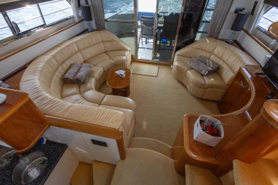 Luxurious interior of a 1995 Princess 60 yacht with beige leather seating and ocean view.